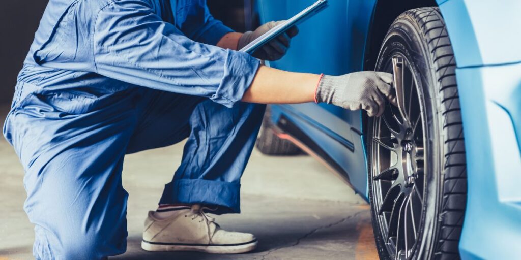 Car mechanic that is doing maintenance on a car