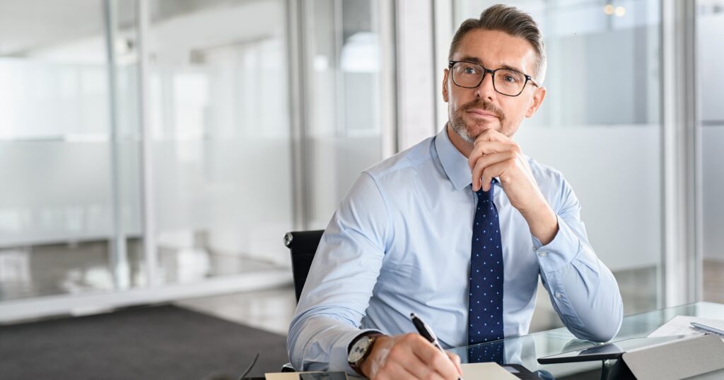 A new business owner at his office desk going over insurance for your business options.